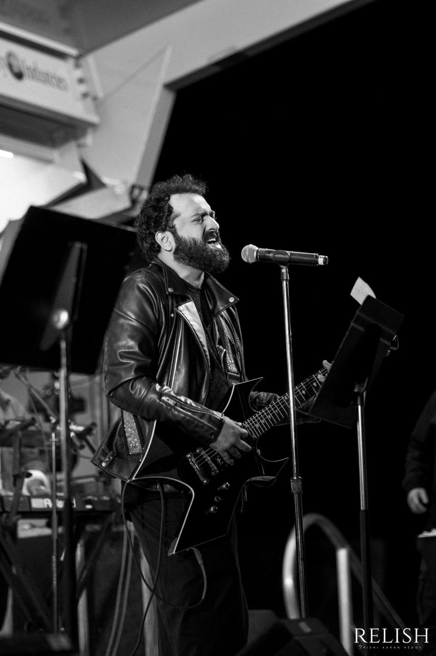 Sri Charan Pakala singing live with guitar on stage